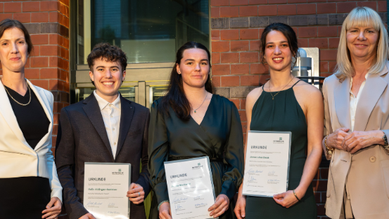 Fünf Personen (v.l.n.r.: Stefanie Sabet, Helix Aldinger-Sommer, Jana Beck, Paula Markwitz, Nikola Steinbock) stehen nebeneinander vor einem Backsteingebäude, drei halten Urkunden, alle tragen formelle Kleidung.